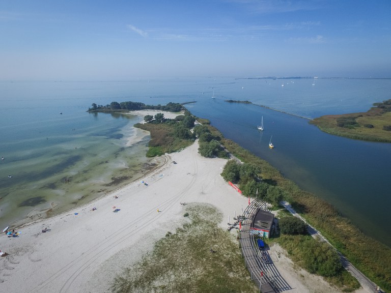 Makkum_strand en pier en zeilboot in vaargeul_IJsselmeer_drone_zomer.jpg