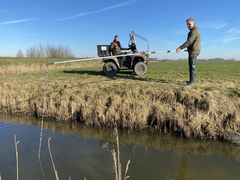 Twee medewerkers van Wetterskip Fryslân peilen de waterdiepte in een hoofdwatergang. (Foto Wetterskip Fryslân).jpg